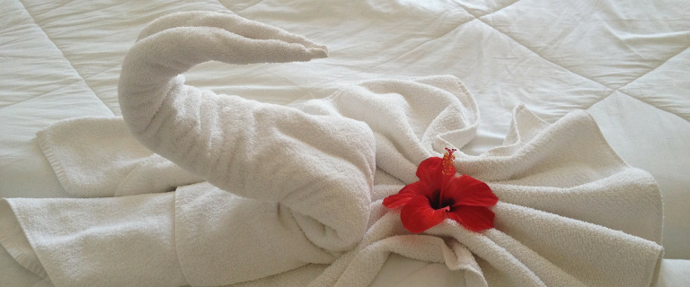 Bettdecke und Handtuch im Hotelzimmer